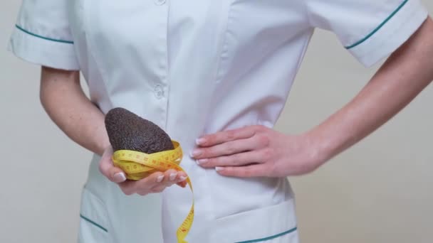 Ernährungswissenschaftler Arzt Konzept eines gesunden Lebensstils - mit Bio-Avocadofrüchten und Maßband — Stockvideo