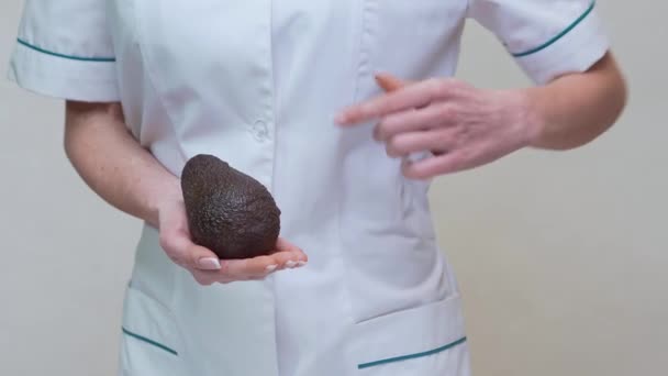 Nutricionista médico concepto de estilo de vida saludable - celebración de aguacate orgánico — Vídeos de Stock