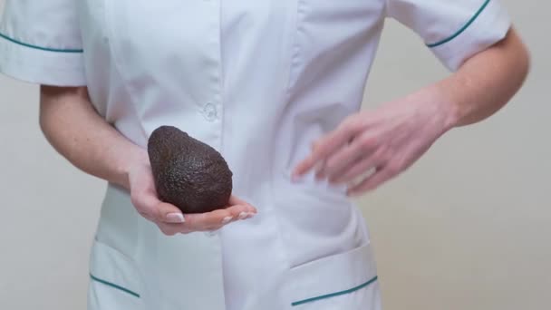 Nutricionista médico concepto de estilo de vida saludable - celebración de aguacate orgánico — Vídeos de Stock