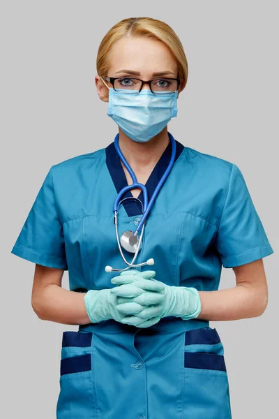 Médico enfermera mujer con estetoscopio con máscara protectora y guantes de goma o látex — Foto de Stock