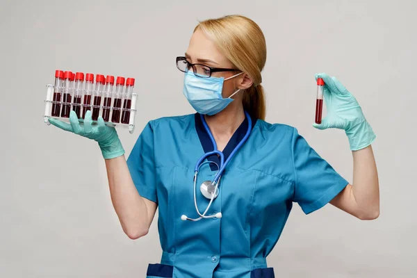 Verpleegkundige vrouw met beschermend masker en handschoenen - rek met virusbloedonderzoek — Stockfoto