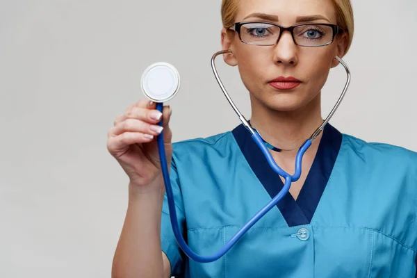 Médico trabajador médico mujer con estetoscopio aislado sobre fondo gris claro —  Fotos de Stock