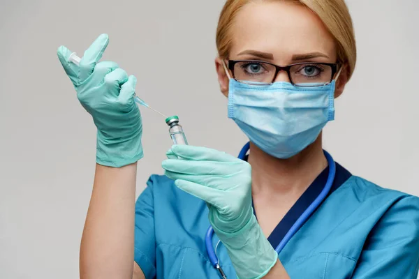 Verpleegkundige vrouw met beschermend masker en handschoenen - spuit vasthouden — Stockfoto