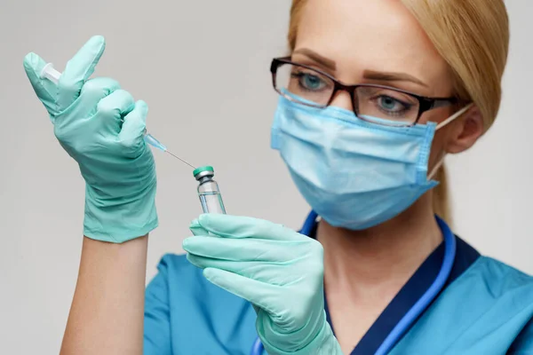 Verpleegkundige vrouw met beschermend masker en handschoenen - spuit vasthouden — Stockfoto