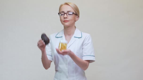 Näringsfysiolog läkare som håller organisk avokado frukt och burk med medicin eller vitamin eller omega 3 kapslar — Stockvideo