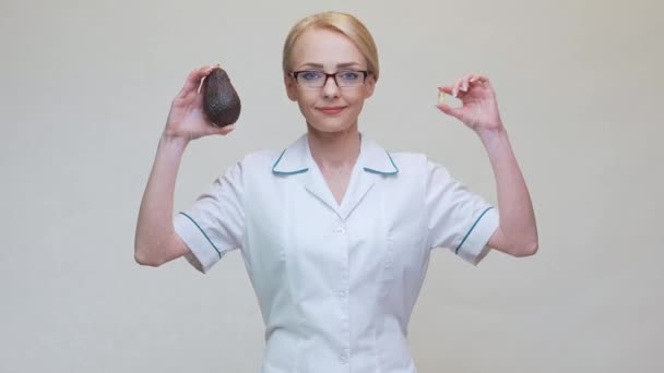 Voedingsdeskundige met biologische avocado fruit en medicijnen of vitamine of omega 3 capsule — Stockvideo