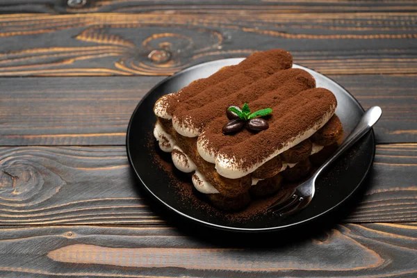 Sobremesa tiramisu clássico na placa de cerâmica em fundo de madeira — Fotografia de Stock