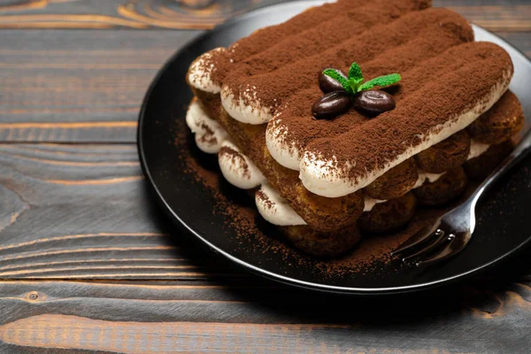 Sobremesa tiramisu clássico na placa de cerâmica em fundo de madeira — Fotografia de Stock