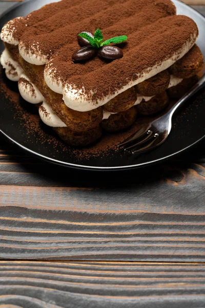 Klasik tiramisu tatlısı seramik tabakta ahşap arka planda — Stok fotoğraf