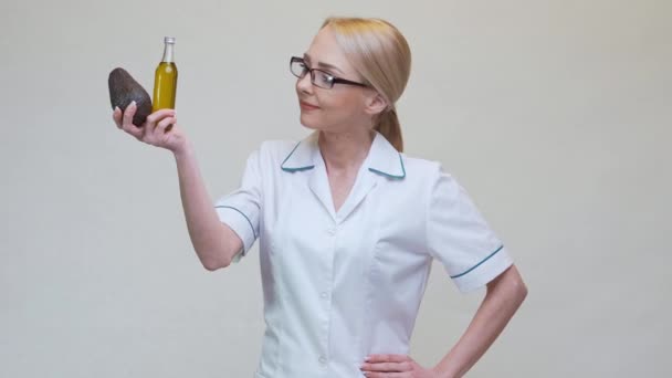 Lekarz dietetyk posiadający organiczne owoce awokado i butelkę oleju — Wideo stockowe