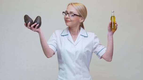 Nutricionista médico segurando frutas abacate orgânicos e garrafa de óleo — Vídeo de Stock