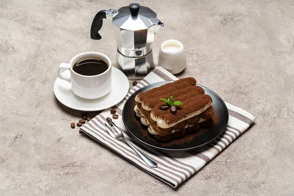 Классический десерт тирамису на керамической тарелке, молоке или сливках и чашке кофе на бетонном фоне — стоковое фото