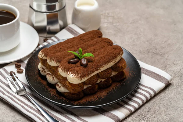 Klassisches Tiramisu-Dessert auf Keramikteller, Milch oder Sahne und Tasse Kaffee auf Betongrund — Stockfoto