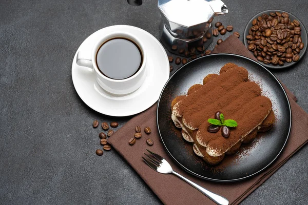 Classic tiramisu dessert on ceramic plate, milk or cream and cup of coffee on concrete background — Stock Photo, Image