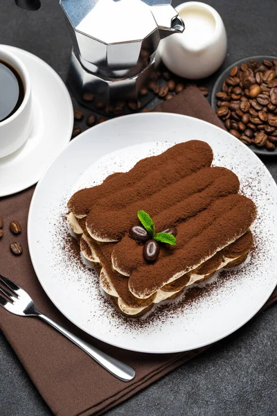 Sobremesa tiramisu clássico na placa de cerâmica, leite ou creme e xícara de café no fundo de concreto — Fotografia de Stock