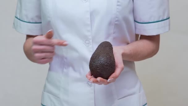 Voedingsdeskundige arts gezonde levensstijl concept - het houden van biologische avocado — Stockvideo