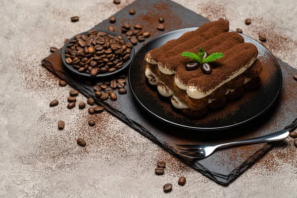 Класичний десерт тірамісу на керамічній тарілці на бетонному фоні — стокове фото