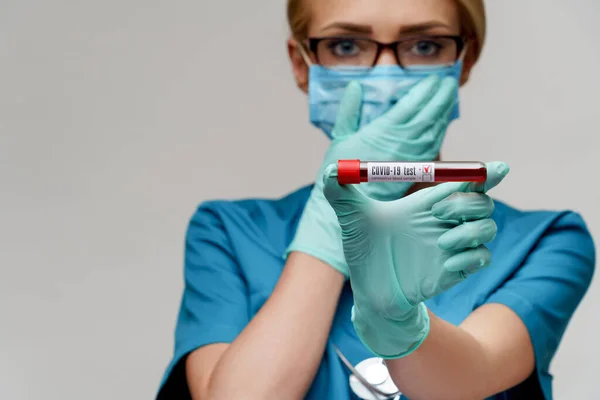 Orvos nővér nő visel védő maszk és kesztyű - gazdaság vírus vérvizsgálat cső — Stock Fotó