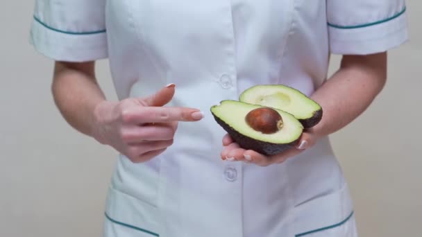 Nutricionista médico concepto de estilo de vida saludable - celebración de aguacate orgánico — Vídeos de Stock