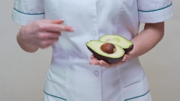 Nutricionista médico concepto de estilo de vida saludable - celebración de aguacate orgánico — Vídeos de Stock