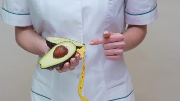 营养学家医生健康的生活方式概念- -持有有机鳄梨水果和测量胶带 — 图库视频影像