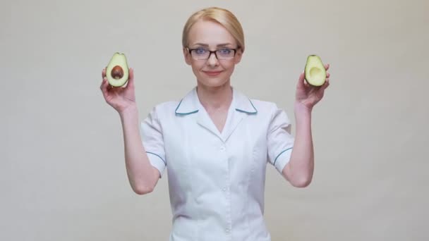 Voedingsdeskundige arts gezonde levensstijl concept - het houden van biologische avocado — Stockvideo