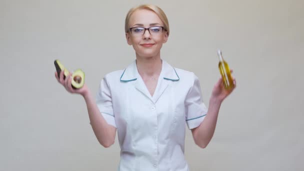 Nutricionista médico segurando frutas abacate orgânicos e garrafa de óleo — Vídeo de Stock