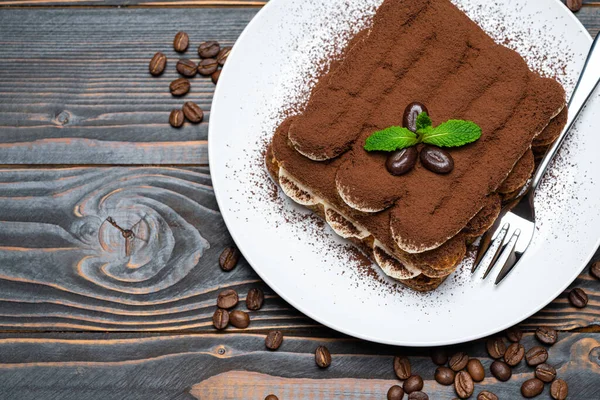 Classic tiramisu dessert on ceramic plate on wooden background — 스톡 사진