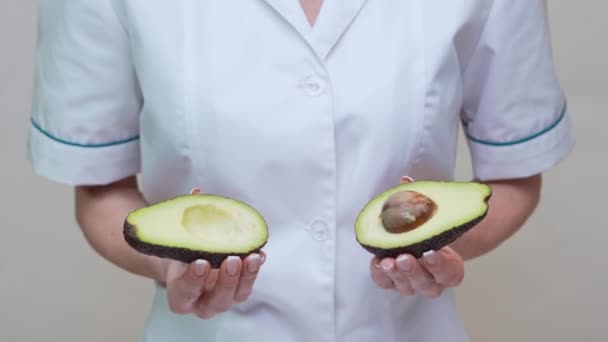 Nutricionista médico concepto de estilo de vida saludable - celebración de aguacate orgánico — Vídeos de Stock