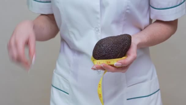 Ernährungswissenschaftler Arzt Konzept eines gesunden Lebensstils - mit Bio-Avocadofrüchten und Maßband — Stockvideo