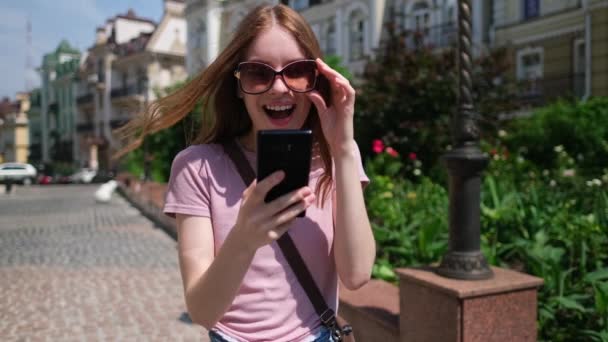 Beautiful Young Woman tourist in the City Center holding phone - Yes winning gesture — Stock Video
