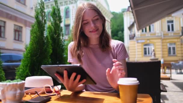 Mujer joven usando tableta PC en un café en una terraza de verano — Vídeo de stock