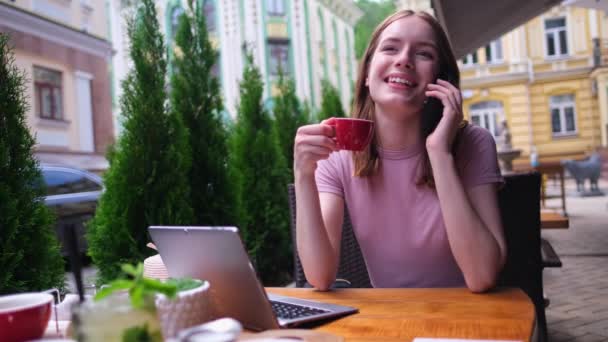 Giovane donna che parla al telefono in un caffè su una terrazza estiva — Video Stock