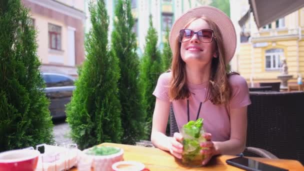 Mladá žena pití mojito koktejl v kavárně terasa v horkém letním dni — Stock video