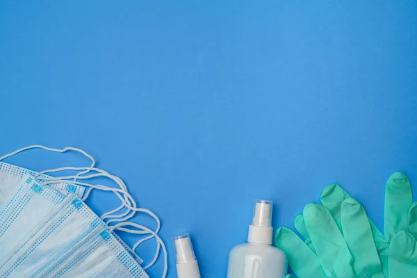 Bottiglia di crema, lozione, disinfettante o sapone liquido, guanti di gomma di lattice e maschera protettiva su sfondo blu — Foto Stock