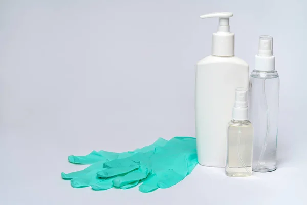 Флакон лосьона, дезинфицирующего средства или жидкого мыла и защитной маски на светло-сером фоне — стоковое фото