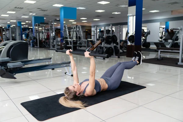 Joven hermosa mujer haciendo ejercicio de fitness entrenamiento abdominal en el club de fitness —  Fotos de Stock