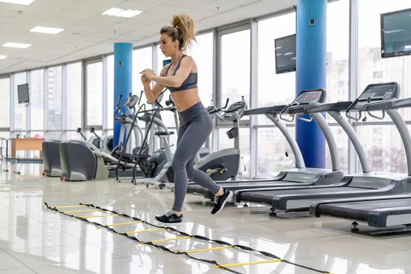 Young woman cardio exercising jumping at gym fitness center — Stock Photo, Image