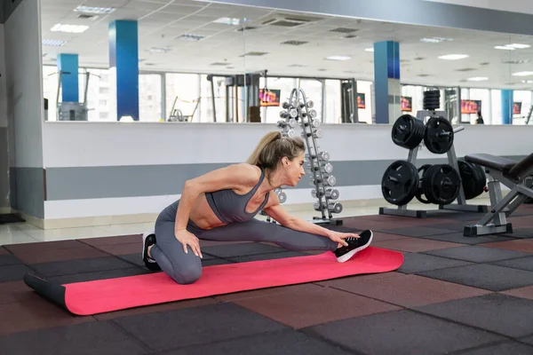 Mujer joven estirando el ejercicio en el gimnasio —  Fotos de Stock