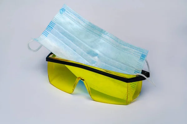 Маска и защитные очки для персональной защиты на светло-сером фоне — стоковое фото