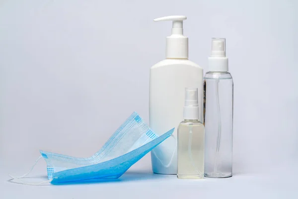 Flasche Lotion, Desinfektionsmittel oder Flüssigseife und Schutzmaske über hellgrauem Hintergrund — Stockfoto