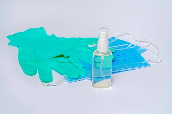 Fles lotion, ontsmettingsmiddel of vloeibare zeep en beschermmasker over lichtgrijze ondergrond — Stockfoto