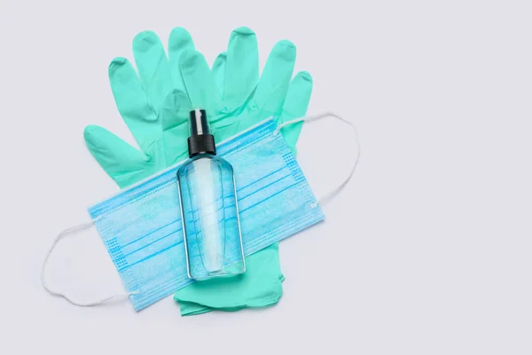 Flat layout of hygiene items - latex gloves, mask and hand sanitizer over light grey background — Stock Photo, Image