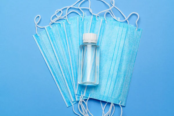 Butelka balsamu, mydła lub płynu oraz maska ochronna na niebieskim tle - płaski układ — Zdjęcie stockowe