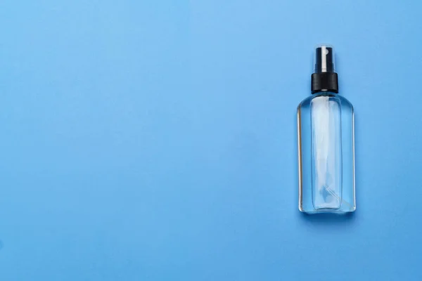 Fles van antiseptische alcohol hand reinigt spray op een blauwe achtergrond voor de preventie van coronavirus - vlakke lay-out met kopieerruimte — Stockfoto