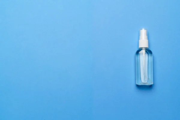 Fles van antiseptische alcohol hand reinigt spray op een blauwe achtergrond voor de preventie van coronavirus - vlakke lay-out met kopieerruimte — Stockfoto