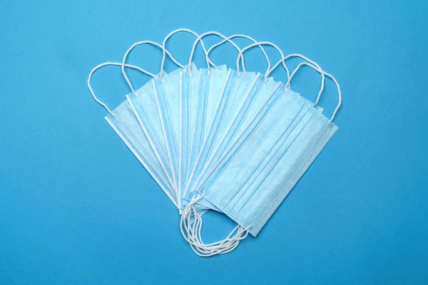 Disposable blue medical face mask on blue background — Stock Photo, Image