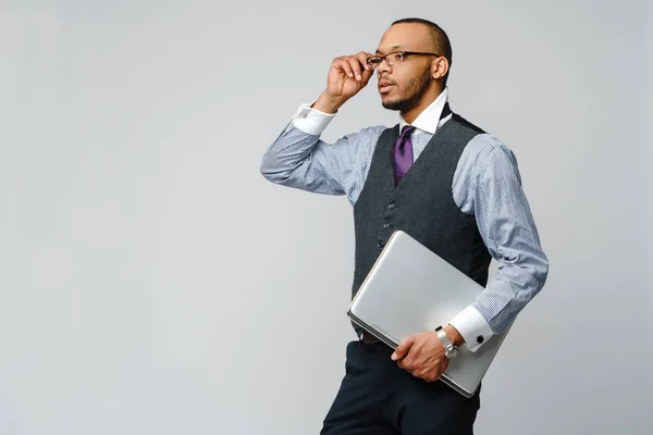 Hombre de negocios afroamericano profesional sosteniendo computadora portátil —  Fotos de Stock