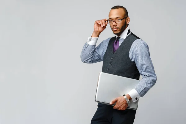 Hombre de negocios afroamericano profesional sosteniendo computadora portátil —  Fotos de Stock