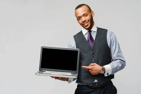 Hombre de negocios afroamericano profesional sosteniendo computadora portátil —  Fotos de Stock